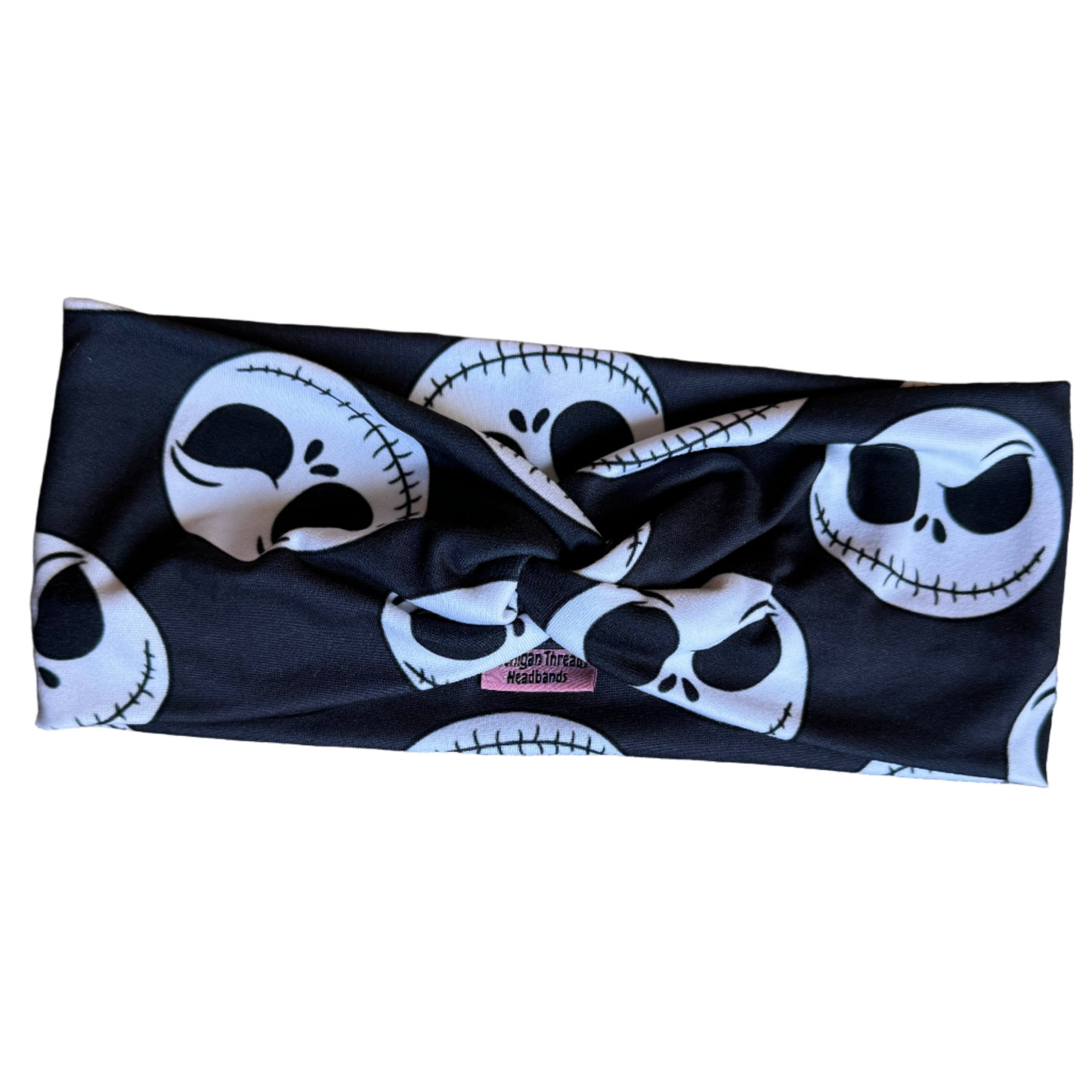 Black headband with white skull designs on a textured surface