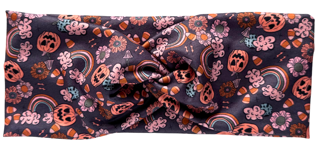 A workout headband with a twisted pattern featuring a variety of colors including pink, orange, and black, with decorative elements that give a Halloween-like appearance. The headband is displayed with a 'New' label on the top left corner.