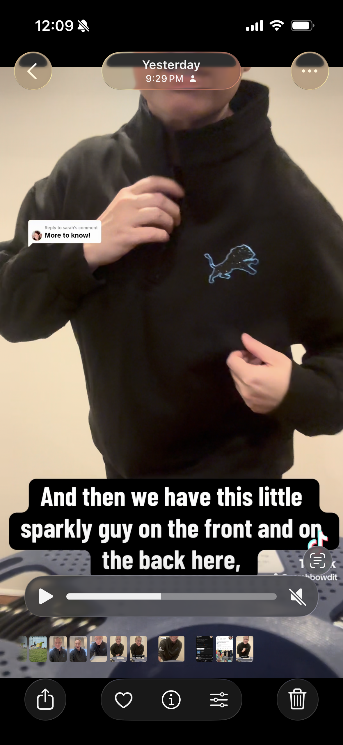 A person wearing a black zip-up hoodie with a small blue lion logo on the left chest, shown in a mirror selfie with a phone interface overlay and text caption.