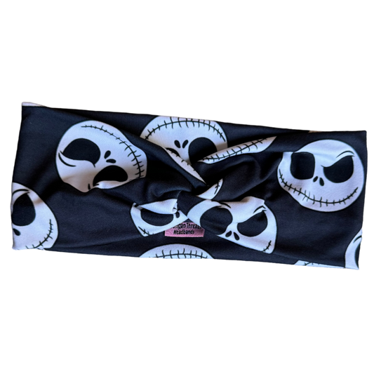 Black headband with white skull designs on a textured surface