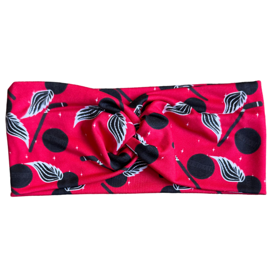 Red headband with black and white patterns on a gray textured background